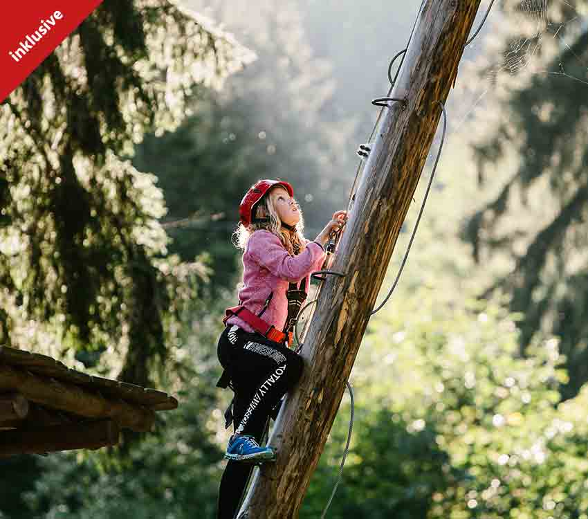 Kind beim Klettern im Waldseilgarten in Pfronten, Allgäu
